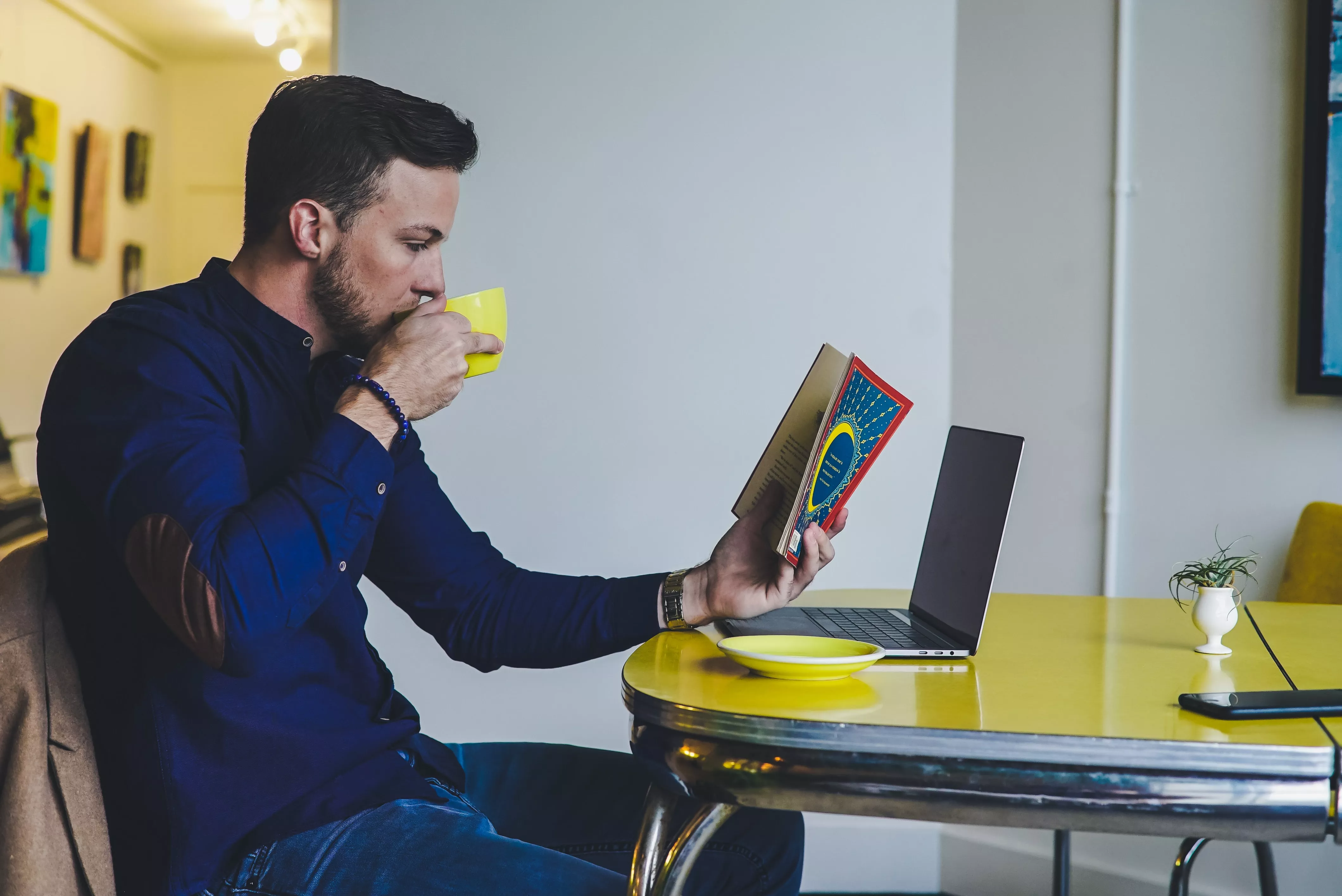 Man reading a book sipping coffee