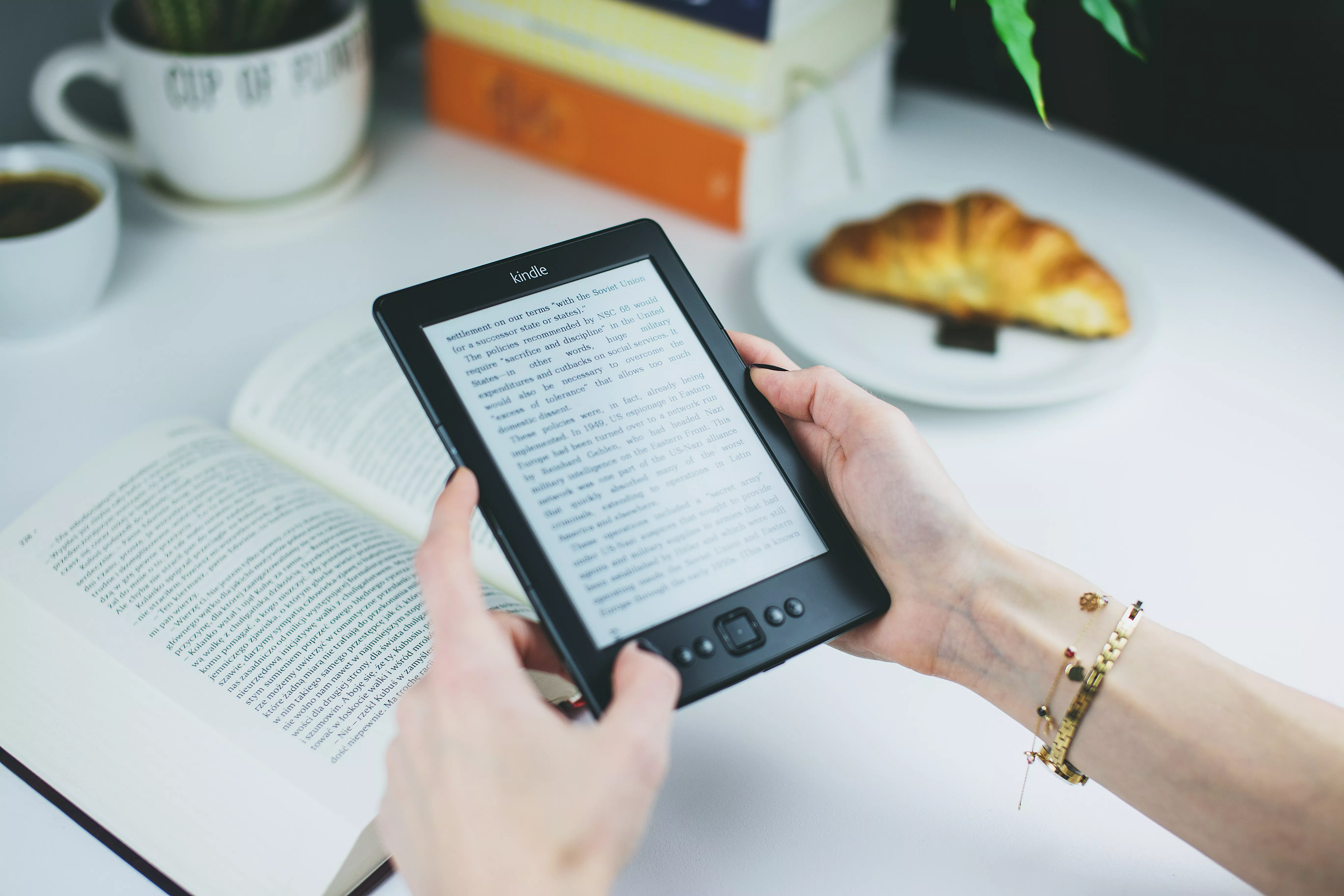 Person reading an ebook at a table with coffee